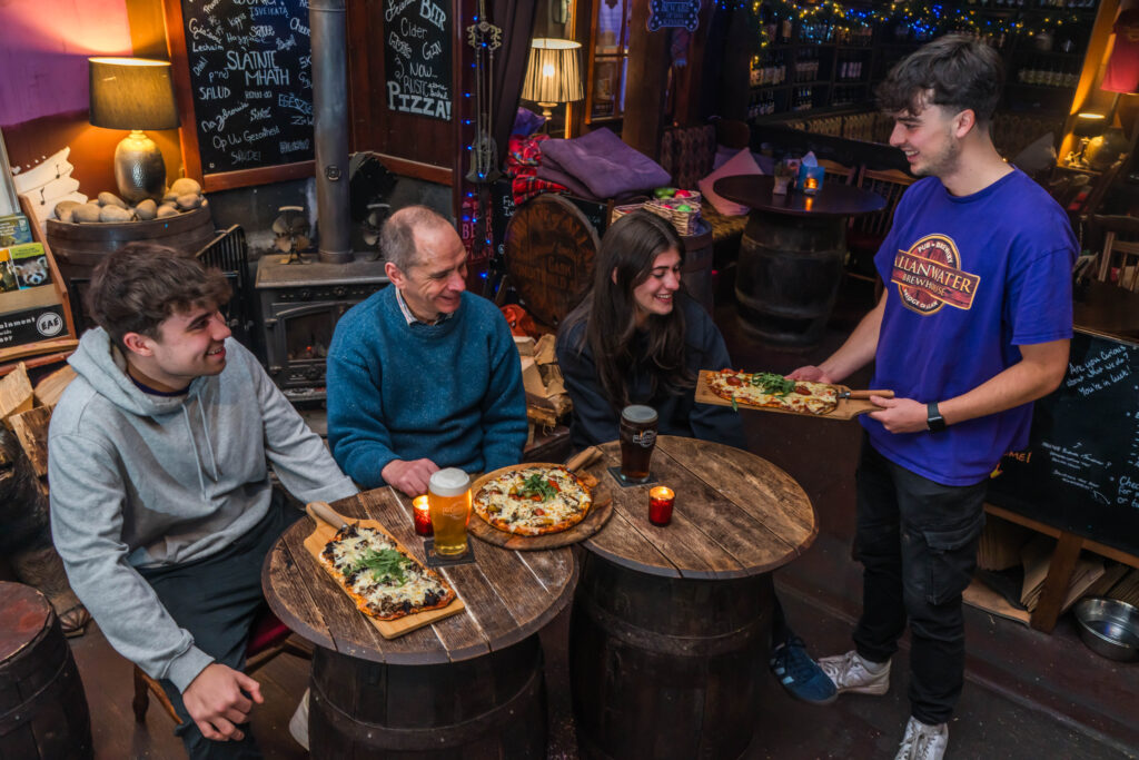 Patrons enjoying pizza and beer