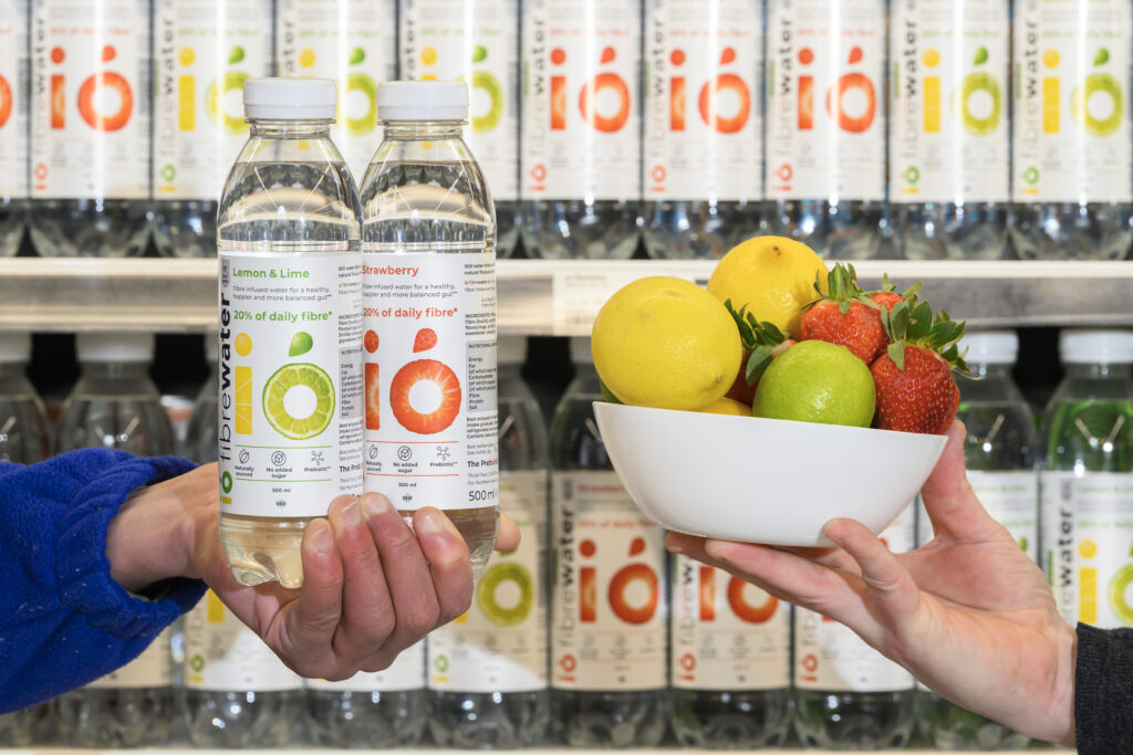 Image of the bottled fibrewater and a bowel of fruit