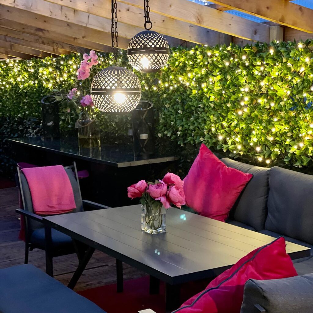Outdoor seatin area with vase of pink flowers