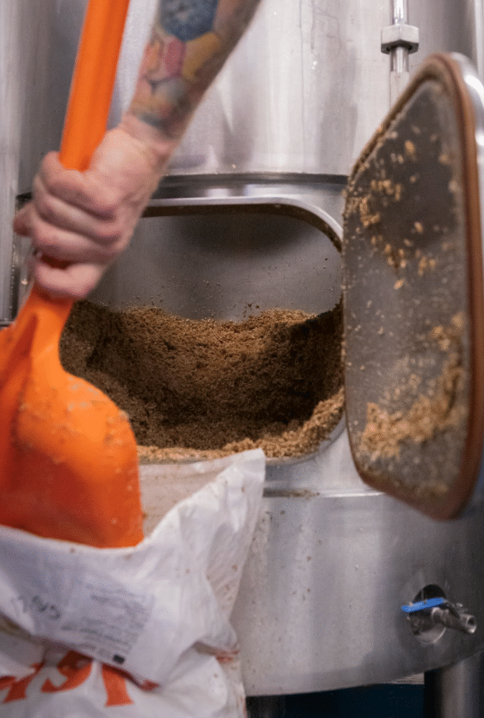 Grain being added to brewing process