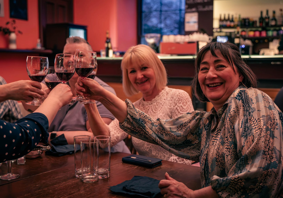 Happy diners, cheers with glasses